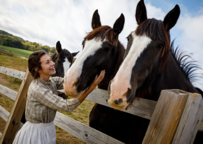 A photo of Anna Coates and the horses at the farm.