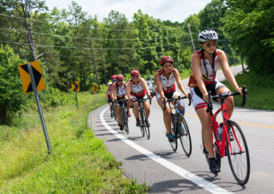 Riders hug the road on the bike tour.