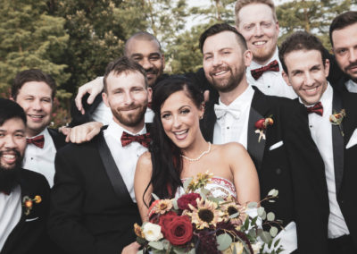 A photograph of the bride with the groomsmen.