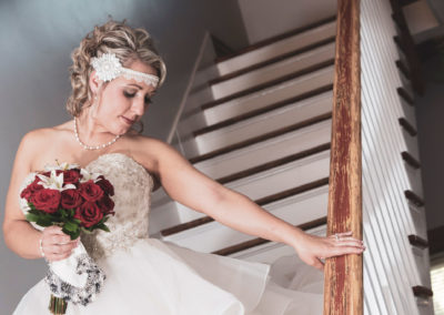 The bride poses for a photo on the hotel staircase.