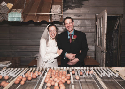 The bride and groom pose for a photo at the family farm after the wedding.