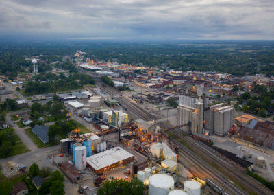 An aerial view of a Midwestern town with railroad tracks and grain elevators.