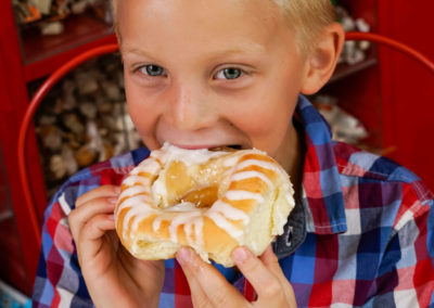 A young boy eating a Danish.