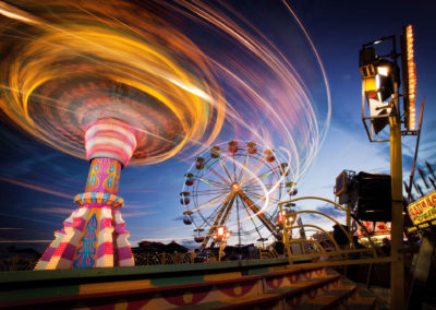A long exposure photo of a carnival ride at twilight.
