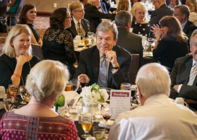 Attendees talk at dinner.