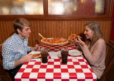 A young couple dines on pizza.