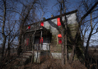 A nocturnal snapshot of a unoccupied house illumined with red light.