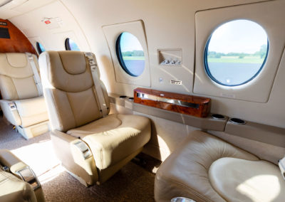 A photograph of the seats and windows inside the cabin of a jet airplane.