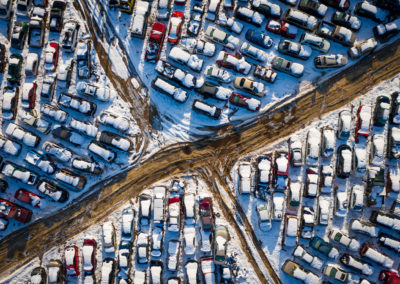 A photograph of rows of parked autos in a junkyard.