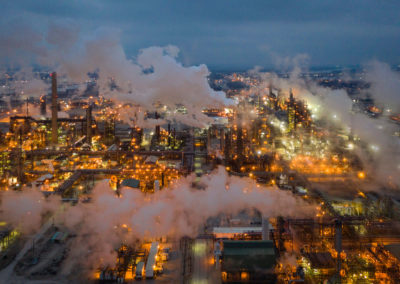 A photograph of a smoky factory at dusk.