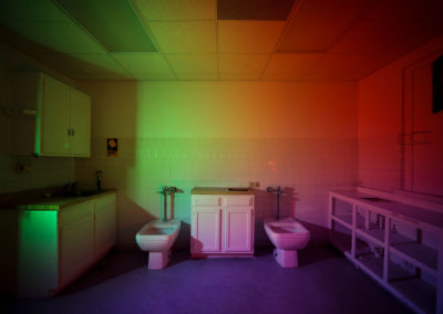 A photo of the embalming room of a funeral home illuminated by the colors of the rainbow.