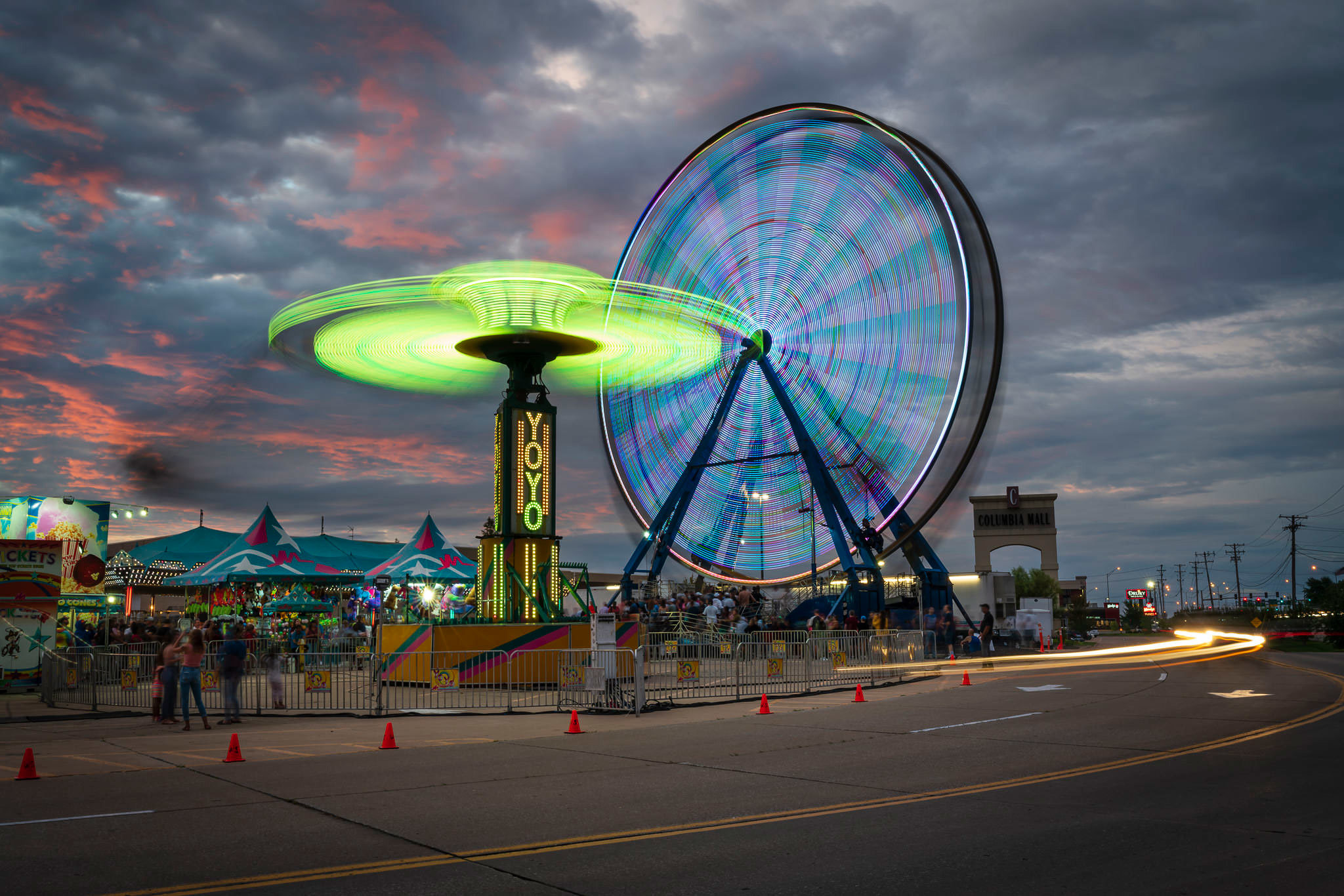 A long exposure photograph of a carnival at dusk.